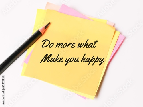 Phrase DO MORE WHAT MAKE YOU HAPPY written on sticky note with a pencil.