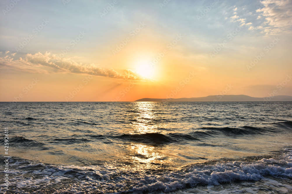 soft waves and sunset sea in different tones in the sky