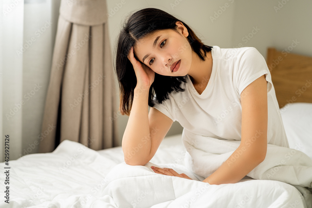 Young women feeling headaches and unhappy on bed, female suffering from migraine. Young women feeling headaches and unhappy on bed, female suffering from migraine.