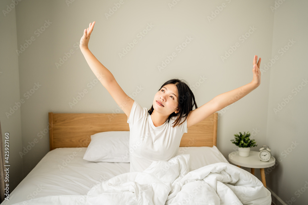 young woman wakes up with stretching exercise on a bed at morning time, lifestyle female holiday. young woman wakes up with stretching exercise on a bed at morning time, lifestyle female holiday.