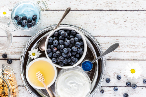 Various healthy ingredients used to make a blue spirulina yogurt parfait.