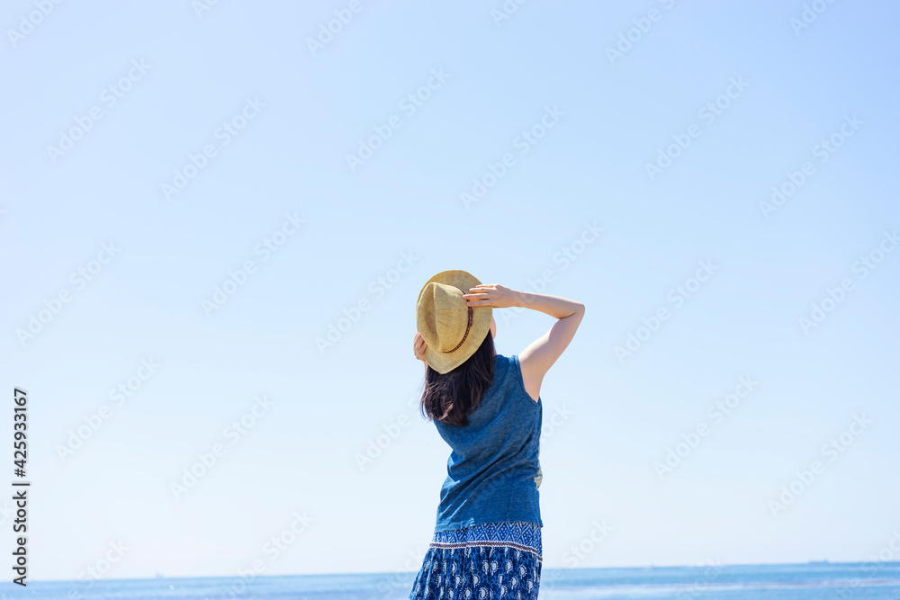 麦わら帽子を被った女性の後ろ姿と青空と海 Stock Photo Adobe Stock