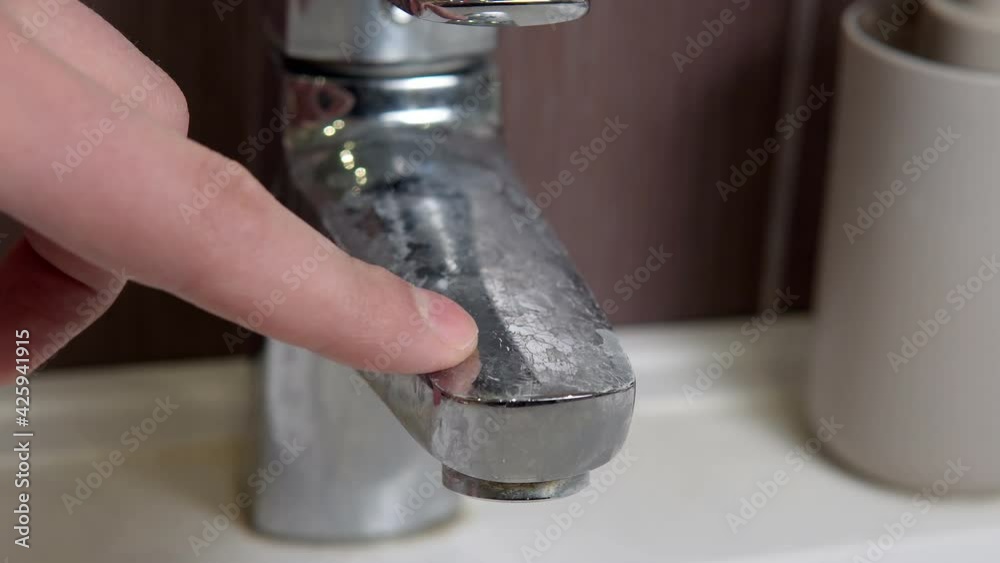 hard water on the tap in the bathroom with limescale, white chalky deposit and stains. Residues and hard water.