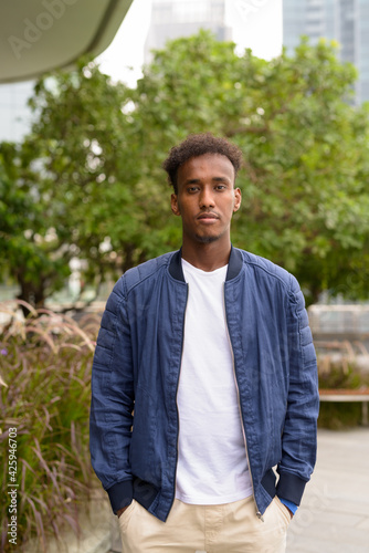 Portrait of handsome black African man at rooftop garden