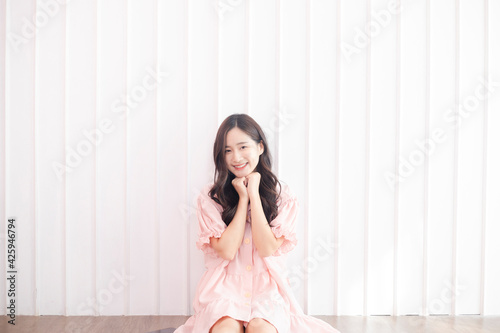 Portrait of beautiful young Asian woman happiness standing on white wall background and smile