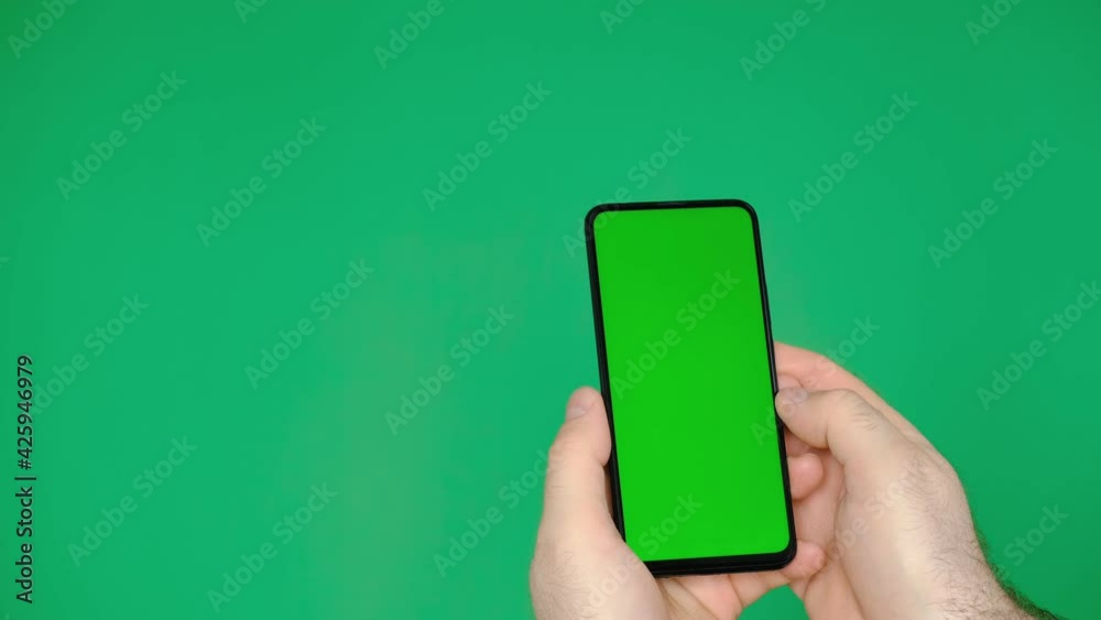 Handheld Camera: Point of View man Holding Chroma Key Green Screen Smartphone Watching Content. Swiping the screen with your finger and tapping the center of the screen Handheld Camera: Point of View man Holding Chroma Key Green Screen Smartphone Watching Content. Swiping the screen with your finger and tapping the center of the screen