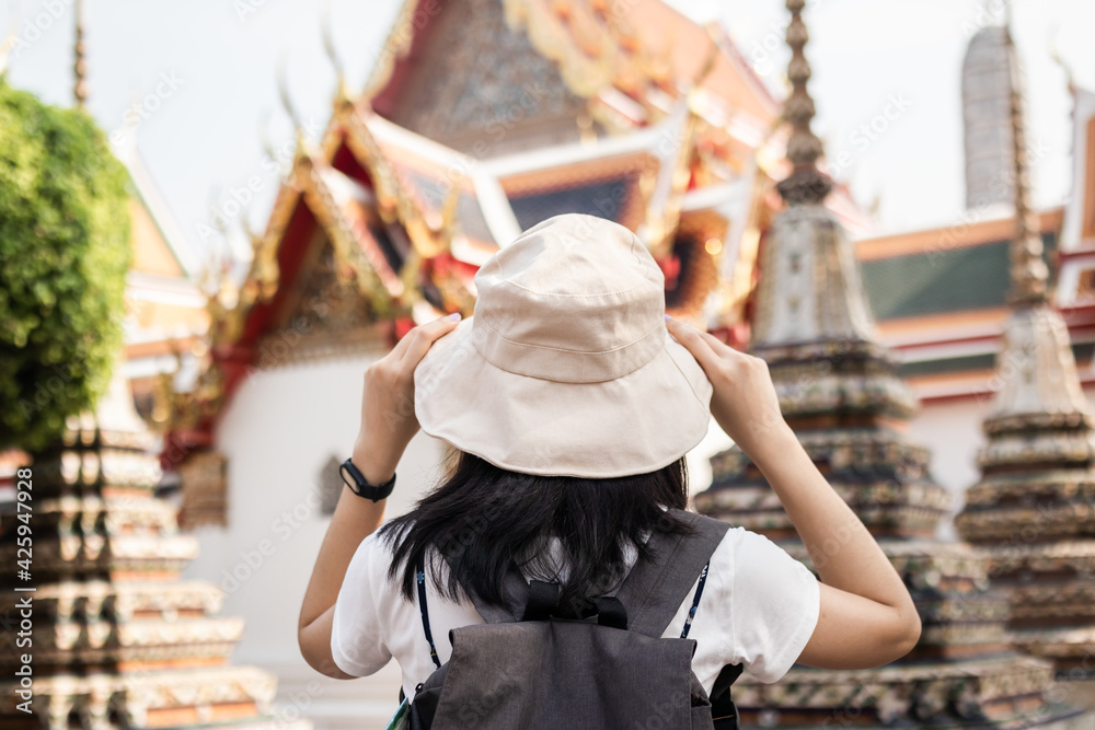 Traveler, travel young asian woman or girl wear hat, look at pagoda temple, city tourism, happy on sunny day. Backpacker tourist, holiday trip,s ummer or vacation, hobby on sunny day concept.