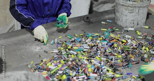 View of the hands of a person in gloves sorting used batteries. Recycling and sorting. Environmental protection concept. photo