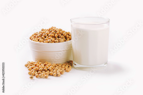 Glass of soy milk with soybean in ceramic bowl isolated on white background.