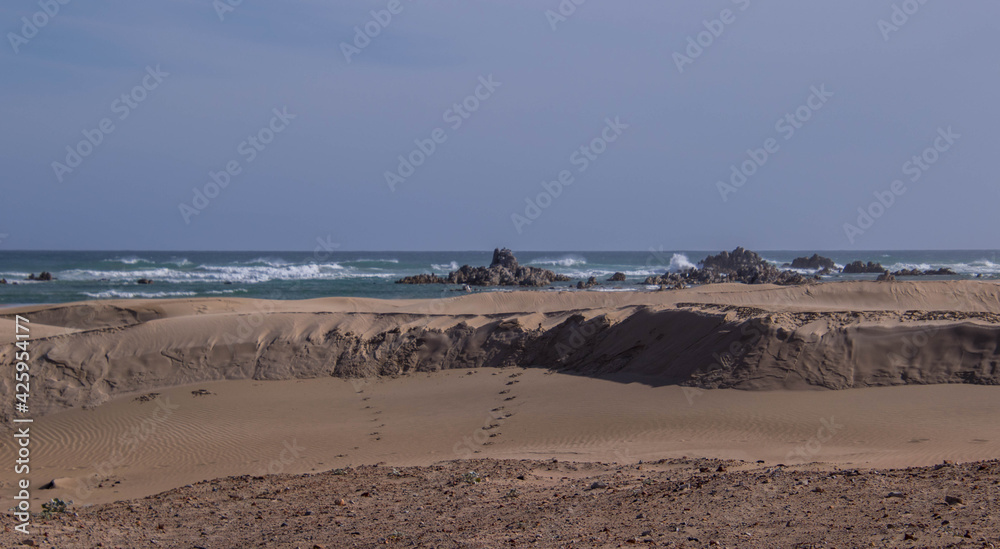 Seascape with sand dune and human footprints Seascape with sand dune and human footprints