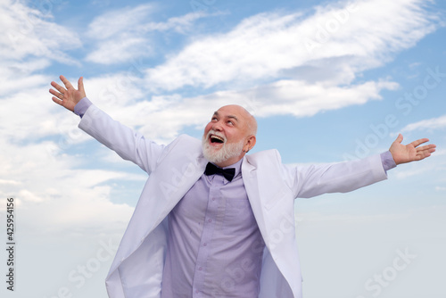 Bussiness success. Old senior mature man. Vintage successful male bussinessman in white suit having fun. photo