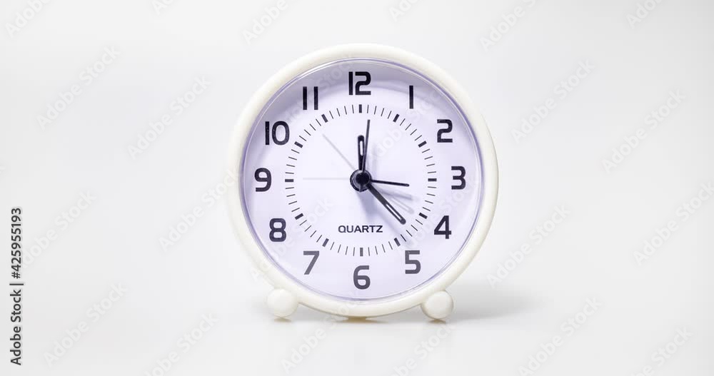 Small white alarm clock show the running time. A modern clock with white frame. Incessantly running time. Close up on a plastic watch with second pointer on white background. Small white alarm clock show the running time. A modern clock with white frame. Incessantly running time. Close up on a plastic watch with second pointer on white background.