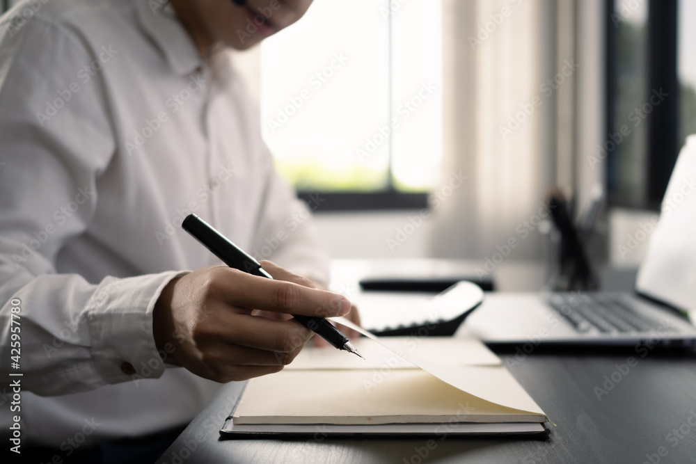 Cropped shot of businessman holding pen and looking information on document. Cropped shot of businessman holding pen and looking information on document.