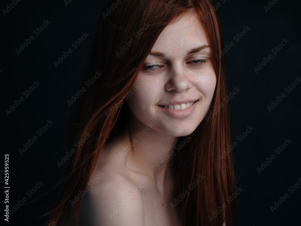 Beautiful woman red hair black background smile model close-up Beautiful woman red hair black background smile model close-up
