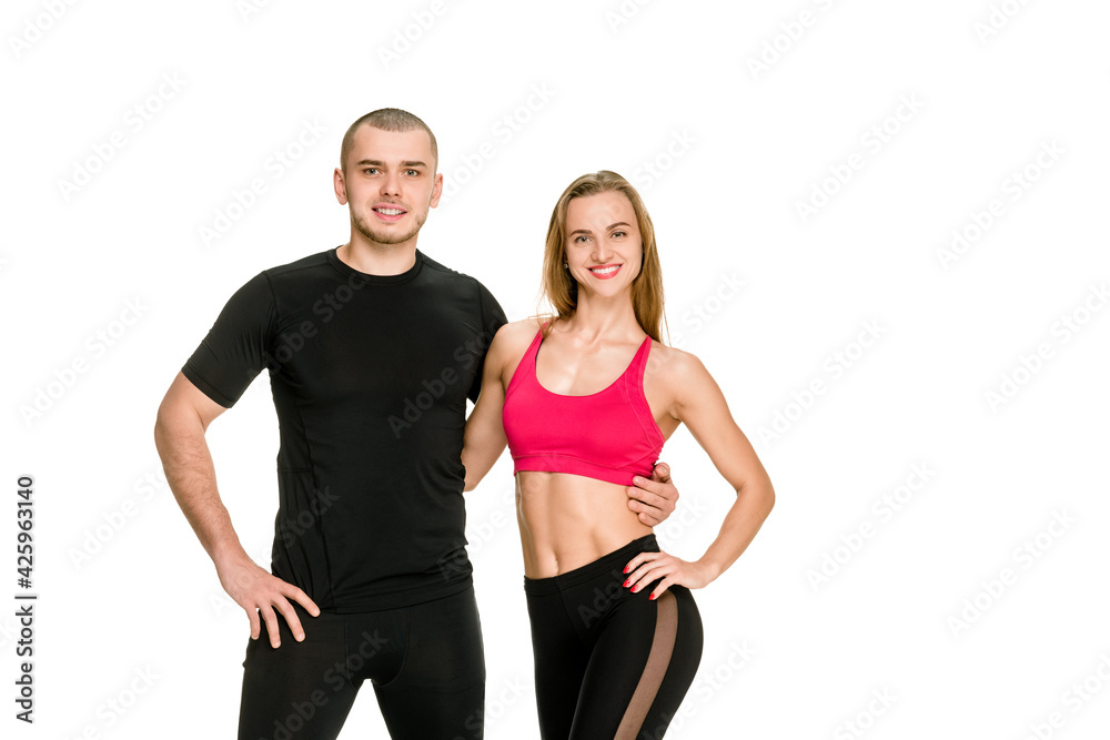Portrait of happy fit young couple in sportswear posing on white background Portrait of happy fit young couple in sportswear posing on white background
