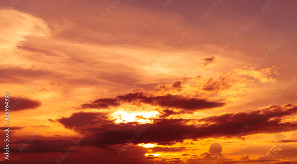 Beautiful sunset sky. Golden sunset sky with beautiful pattern of clouds. Orange, yellow, and dark clouds in the evening. Freedom and calm background. Beauty in nature. Powerful and spiritual scene.