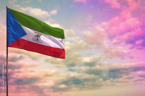 Fluttering Equatorial Guinea flag mockup with the space for your content on colorful cloudy sky background.