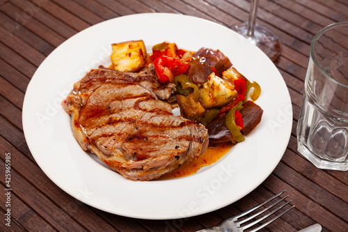 Grilled beef steak served with baked vegetables at plate, nobody