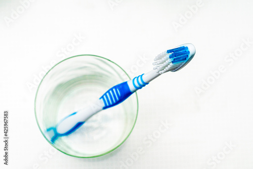 a toothbrush in a glass cup on the bathroom table top view
