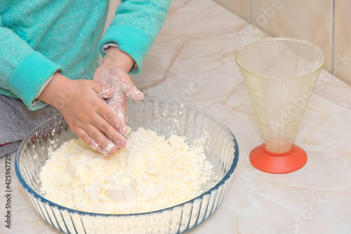 Child with hands in flour cooking in the kitchen