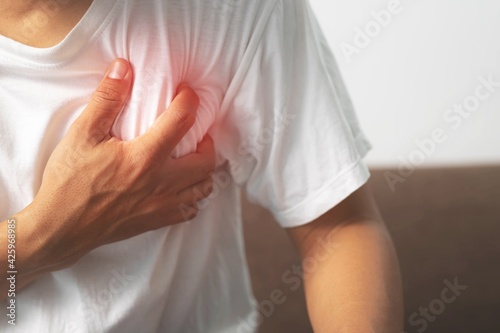 A man white shirt clutching his chest caused by a sudden heart attack.healthcare concept.