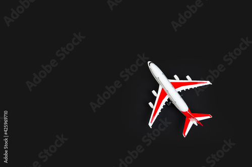 plastic model airplane with red wings against a dark background.