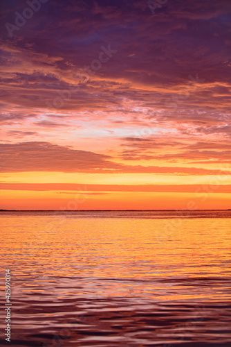 Dramatic sky. Sunrise sun over ocean water. Natural sunset. © Volodymyr