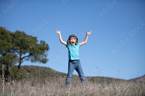 Happiness, childhood, freedom, movement and people concept - happy smiling boy jumping.