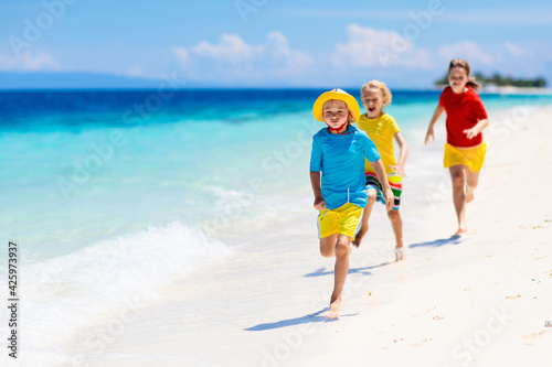 Kids playing on beach. Children play at sea. © famveldman