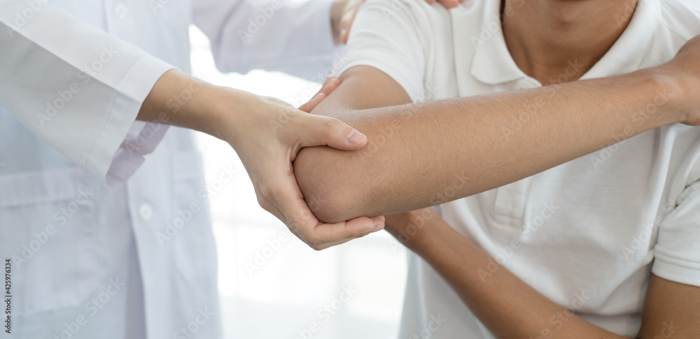 Female physiotherapists provide assistance to male patients with elbow injuries examine patients in rehabilitation centers. Rehabilitation physiotherapy concept Female physiotherapists provide assistance to male patients with elbow injuries examine patients in rehabilitation centers. Rehabilitation physiotherapy concept