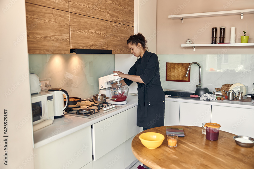 young beautiful mixed race woman is preparing marshmallow at light modern kitchen home young beautiful mixed race woman is preparing marshmallow at light modern kitchen home