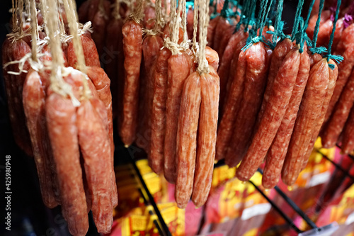 Chinese Preserved Sausages hanging on the grocery store. The southern flavor of Chinese sausage is commonly known by its Cantonese name "lap cheong". Soft focus image.