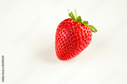 One strawberry on the white background, raw real strawberry