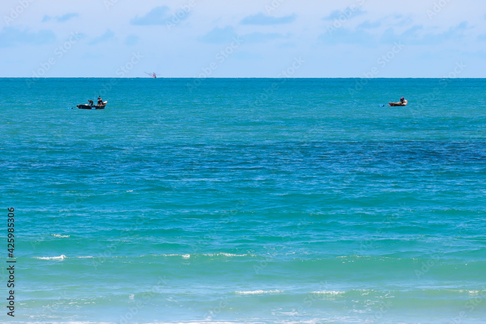 A small fishing boat was sailing in the middle of the sea.