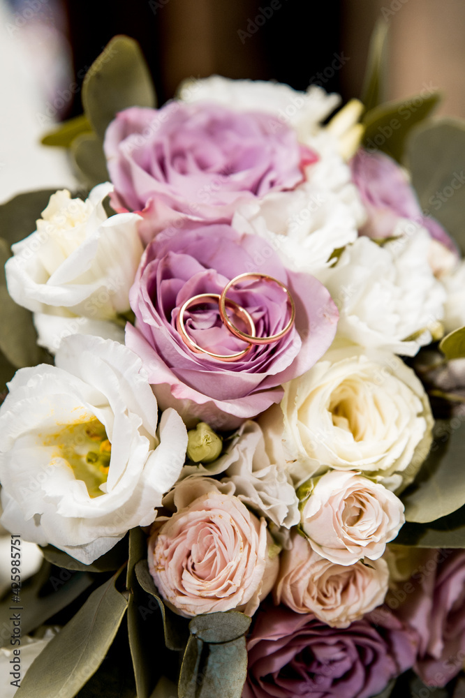 Bridal bouquet with purple and white flowers and rings