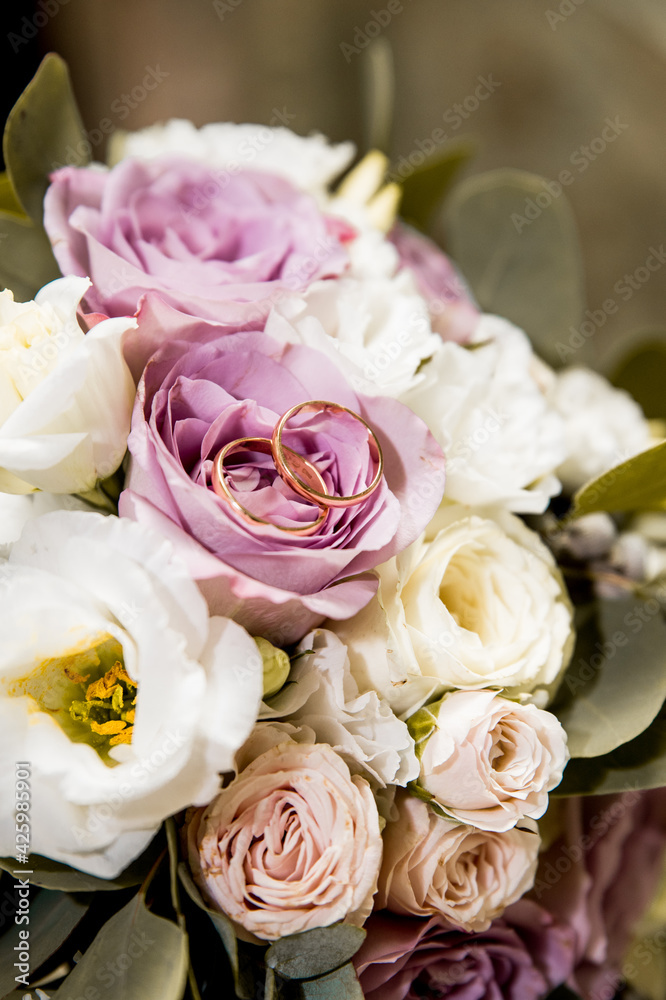 Obraz premium Bridal bouquet with purple and white flowers and rings