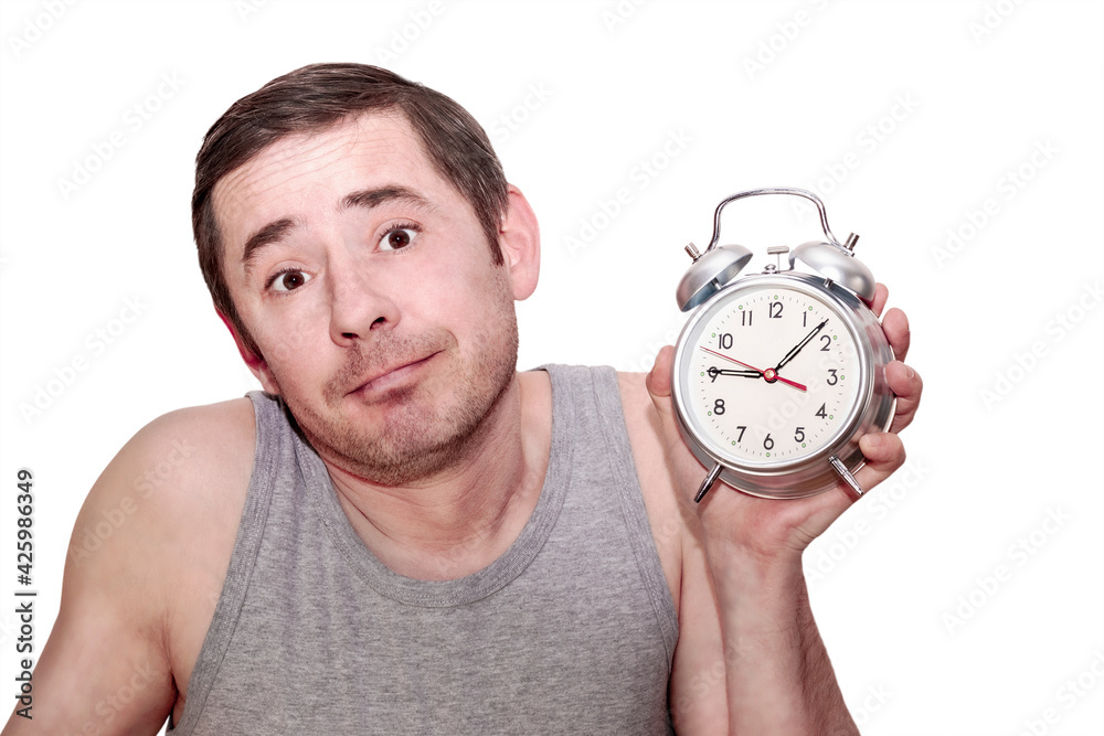 The man slept for work. A man in a raised hand holds an alarm clock. Funny facial expression. Isolated white background.