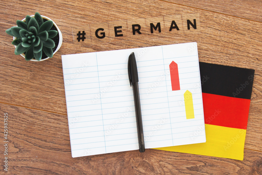 Foto Stock German flag, notebook, pen and inscription hashtag german on a  wooden desktop, foreign language learning concept | Adobe Stock