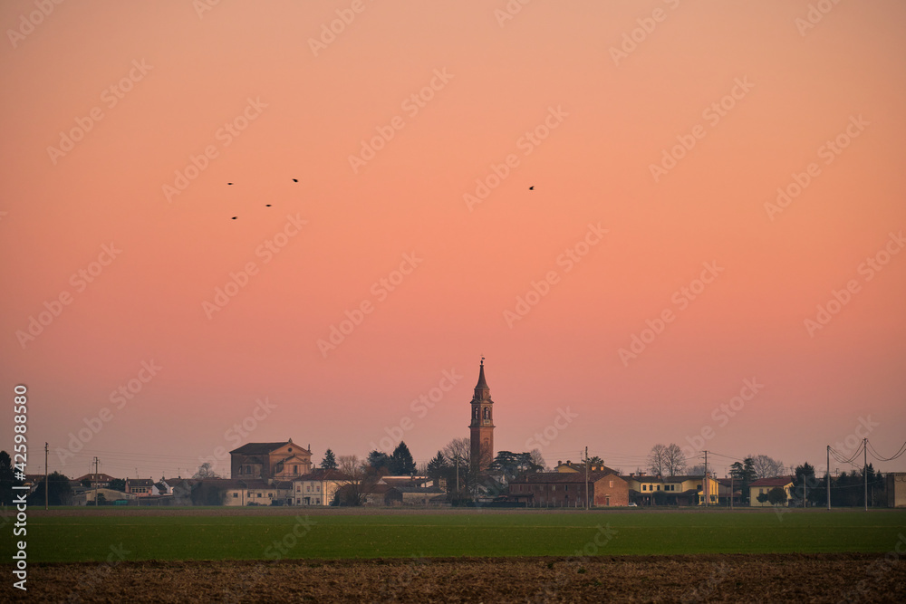 Scenic view of a beautiful and colorful sunset in the countryside of Ferrara