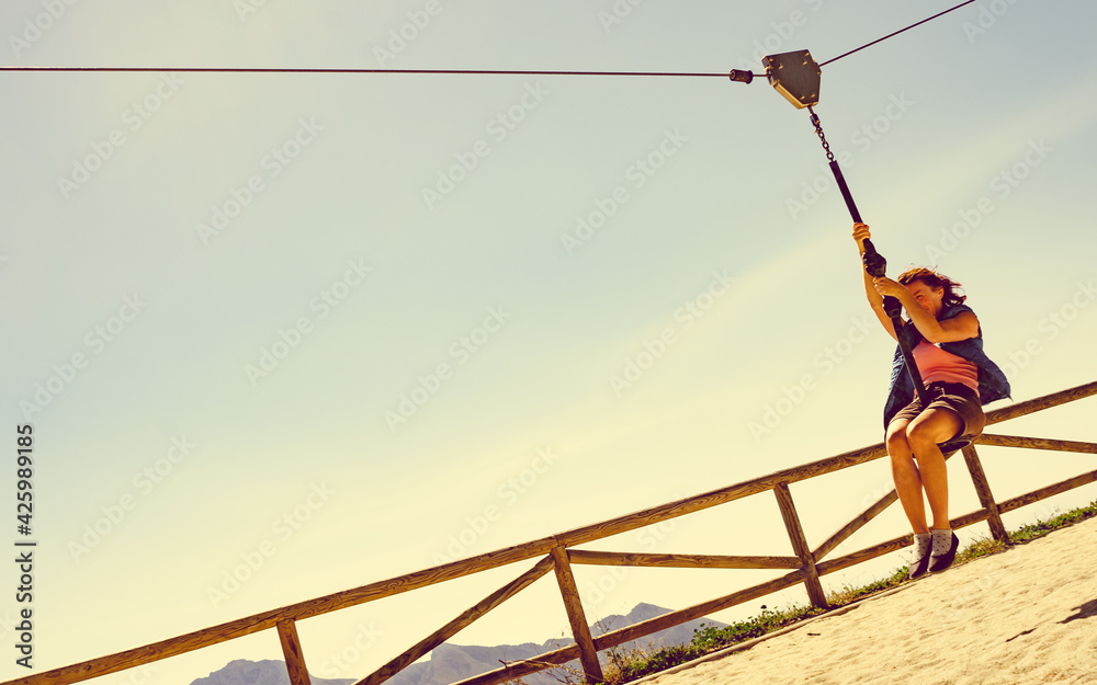 Naklejka premium Adult woman having fun on zipline