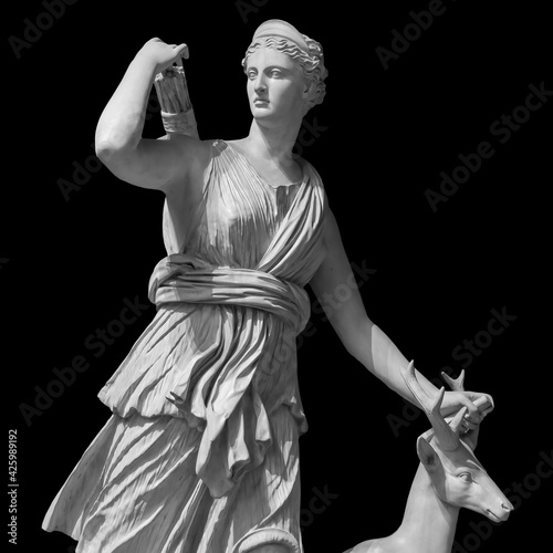 Ancient sculpture Diana Artemis. Goddess of of the moon, wildlife, nature and hunting. Classic white marble statuette isolated on black background photo