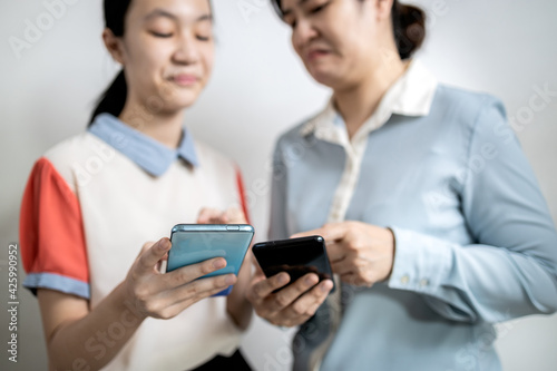 Asian adult woman smirk smile with disdain on her face shows scornful abuse,dissatisfied teenage lady girl with disrespect expressing contempt,envy others,disgust as he reads a message on mobile phone photo