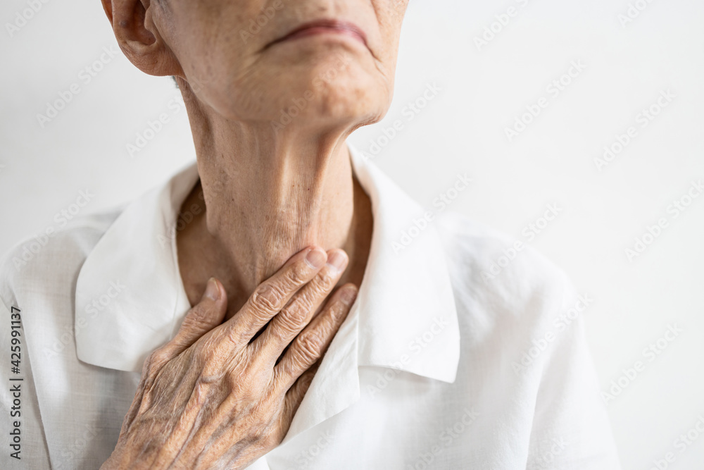 Asian senior patient touching neck with her hand,old elderly has sore throat,foreign body stuck in throat,painful swallowing,pain cough,inflammation of the larynx,throat problems or laryngitis disease - obrazy, fototapety, plakaty 