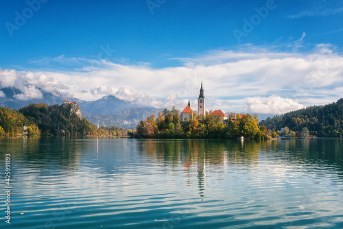 Fototapeta Naklejka Na Ścianę i Meble -  Famous alpine Bled lake (Blejsko jezero) in Slovenia, amazing autumn landscape. Scenic view of the lake, island with church, Bled castle, mountains and blue sky with clouds, outdoor travel background