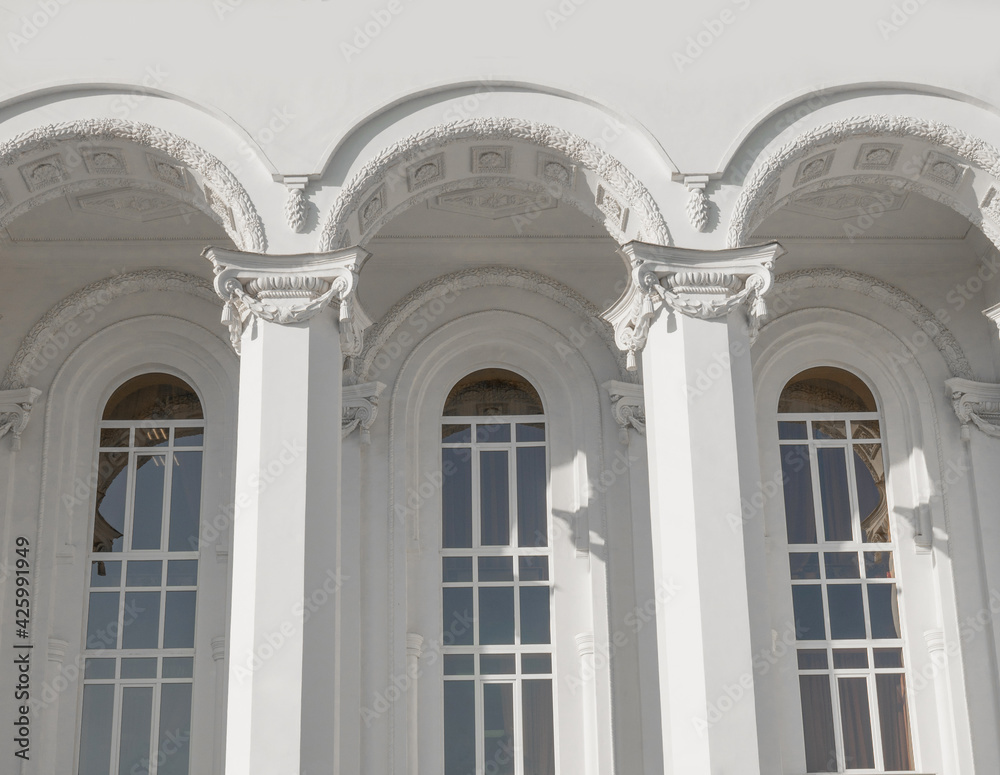 Corinthian columns and long windows. Public building. Ancient Greek temple. White classic columns. Corinthian columns and long windows. Public building. Ancient Greek temple. White classic columns.