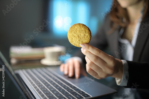 Businesswoman hand holding a cookie in the night