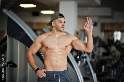 Fit and muscular arabian man posing in gym.