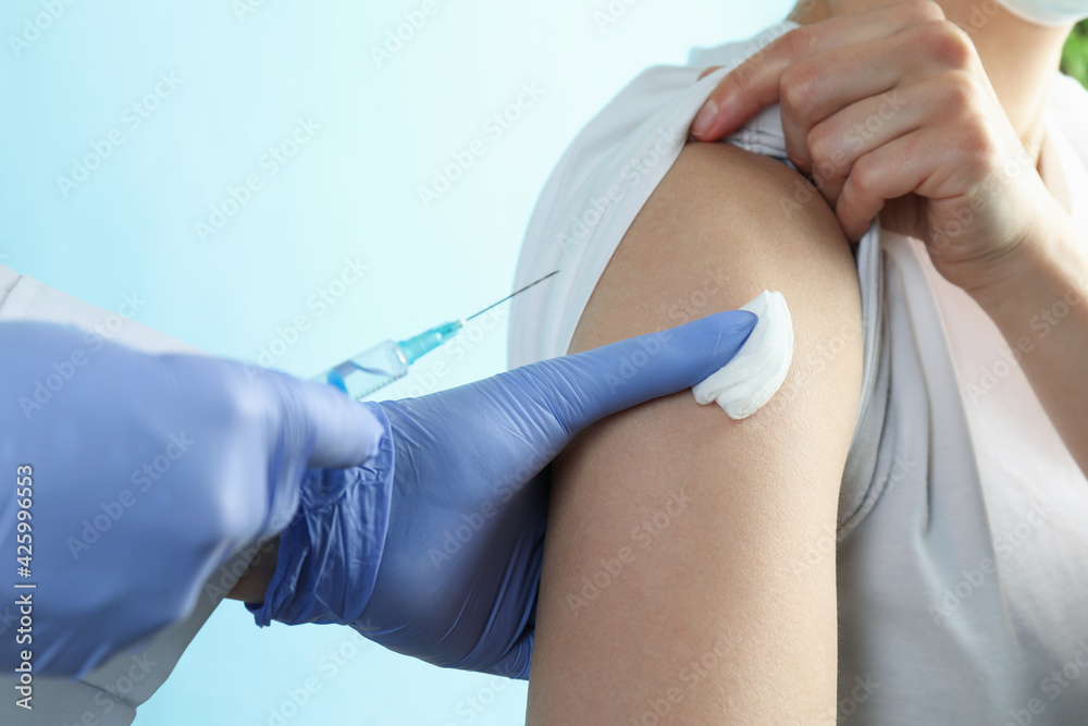 A doctor inject a woman on blue background A doctor inject a woman on blue background