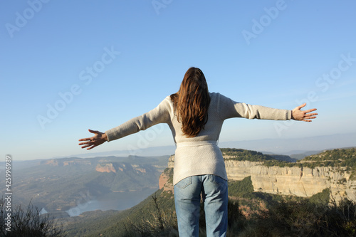 Back view of a woman celebrating vacation in the mountain