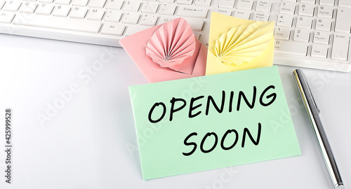 Colorful envelope with pen on keyboard on white background with text opening soon